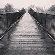 Wooden bridge over river in rain