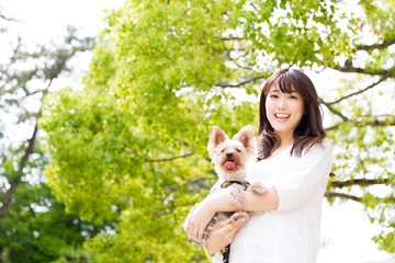 Wall Mural - portrait of young asian woman with dog in the park