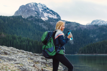 young woman stopping for a water break while hiking