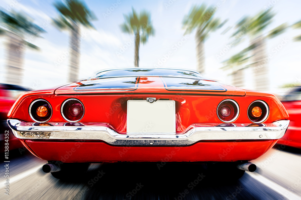 Back view of classic 1972 Chevrolet Camaro in orange color, in motion. Speeding. - obrazy, fototapety, plakaty 