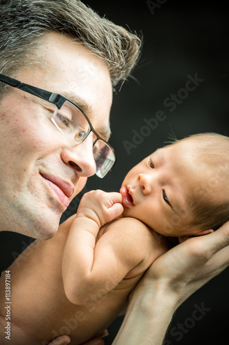 Plakat Szczęśliwy ojciec trzyma z miłością jego nowonarodzonego syna