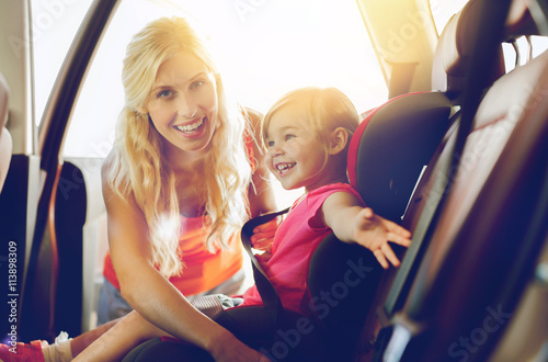 Fotografia, Obraz happy mother fastening child with car seat belt