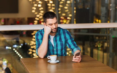 man with smartphone and coffee at restaurant