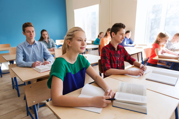 group of students with books at school lesson