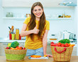 © Yuriy Shevtsov - Young woman standing in kitchen with wegetables show thumb up.