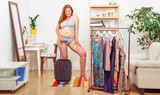 Fat woman in underwear or lingerie trying dresses at home