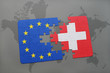 puzzle with the national flag of switzerland and european union on a world map background.