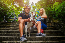Couple Posing With Ther Dog After Bycicle Riding.