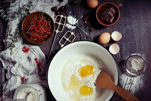 Fotografía Ingredients for fruit and chocolate cake in rustic kitchen