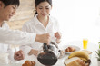© Monet - Young couple is eating breakfast with a laugh