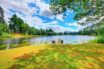 Summer landscape on the river bank with two chairs. McNiel island, Washington