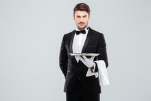 Handsome Yong Waiter In Tuxedo And Gloves Holding Empty Tray