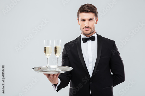 Fotografía Butler in tuxedo holding tray with two glasses of champagne