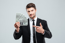 Attractive Young Businessman Holding Money And Pointing On It
