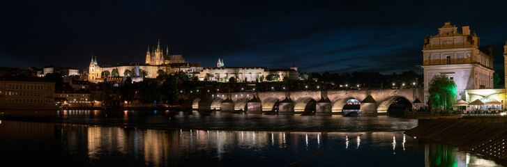 Wall Mural - Panorama of Prague with Vltava river in the foreground, Charles Bridge on right and St. Vitus Cathedral on the horizon. Night skyline