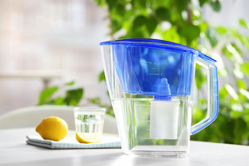 Canvas Print - Water filter jug with lemon and glass on light wooden table