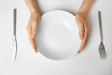 Canvas Print - Female hands and empty plate isolated on white