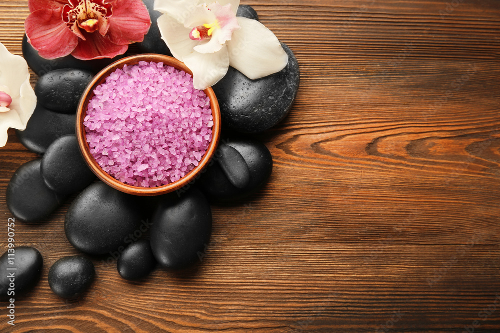 Beautiful spa composition with stones and orchids on wooden background