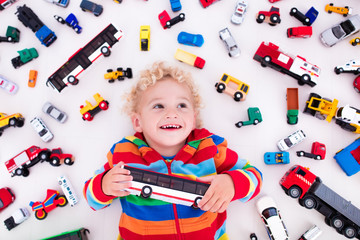 Wall Mural - Little boy playing with toy cars