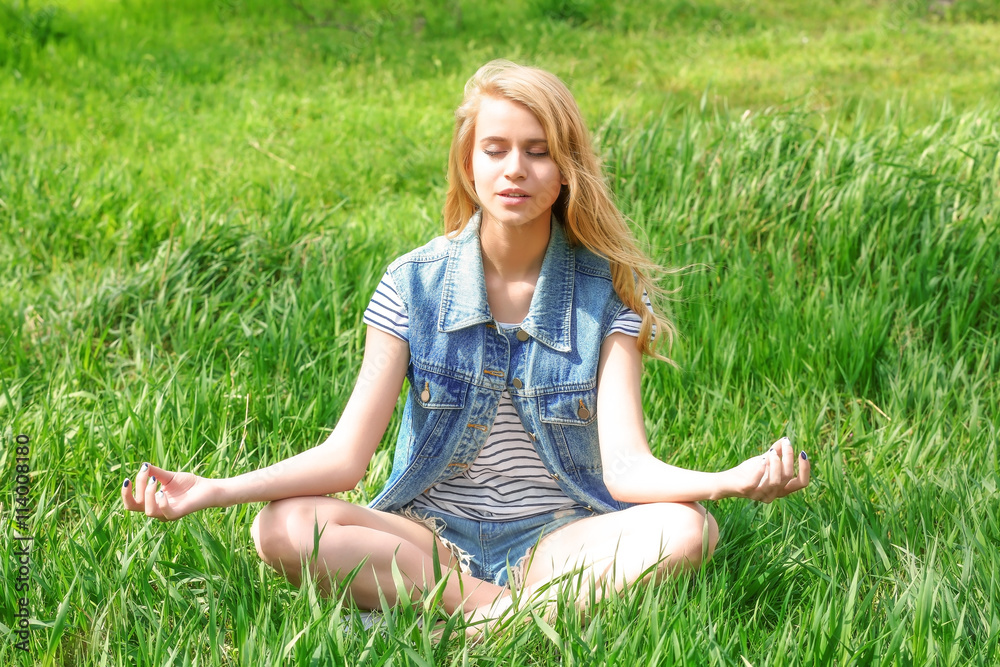 Young beautiful woman on green grass