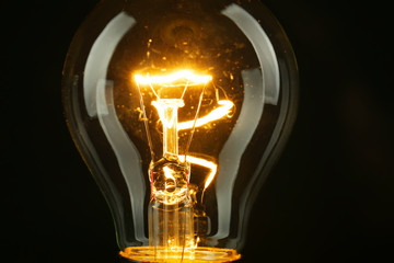 Illuminated light bulb on black background