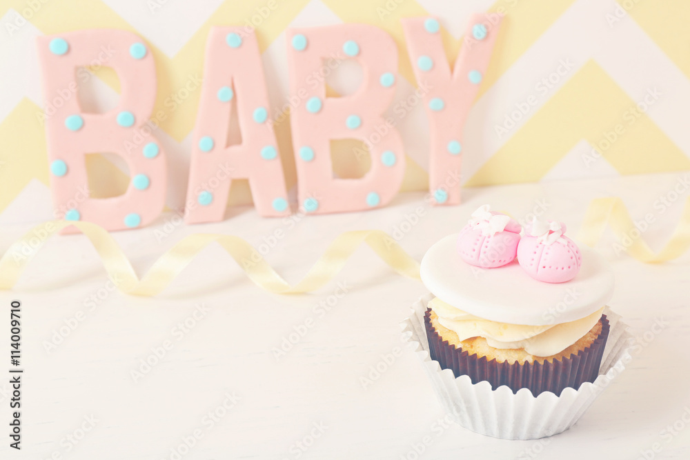 Word "Baby" with cupcake on bright background