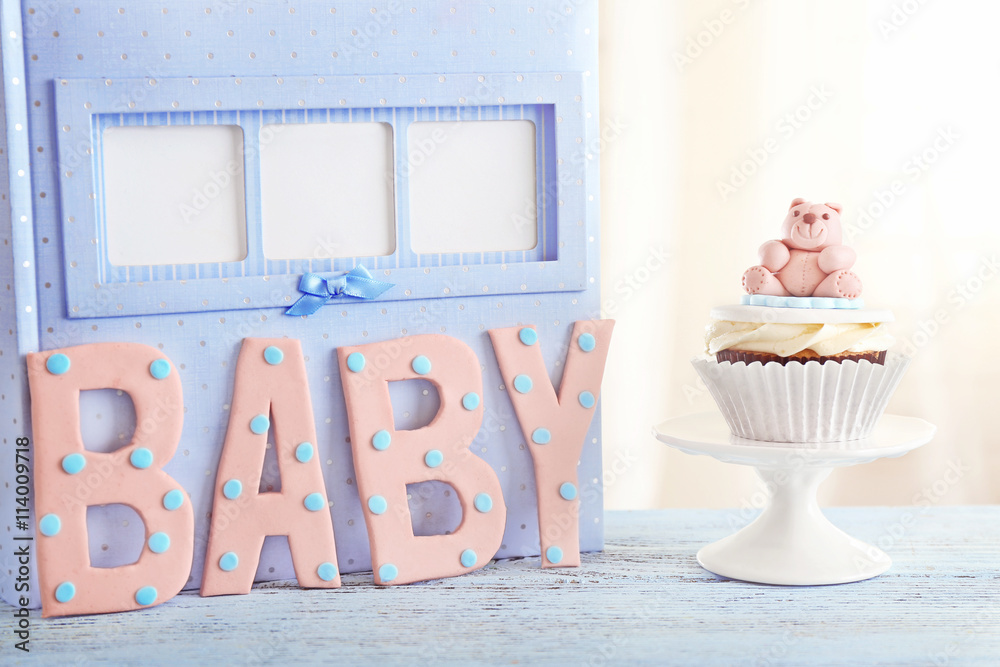 Word "Baby" with cupcake on bright background