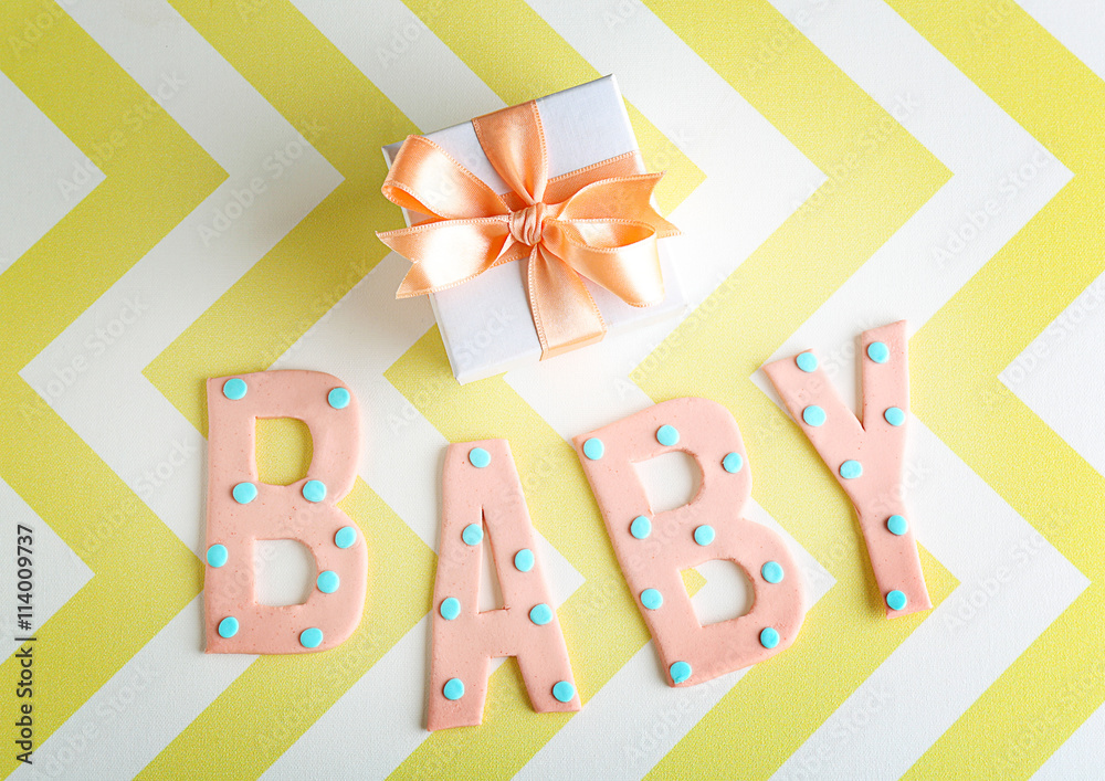 Word "Baby" and gift box on color background