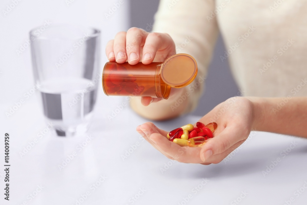 Woman taking vitamins, closeup