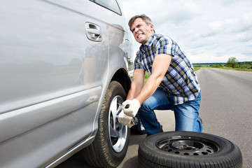 Sticker - Man changing a spare tire of car