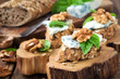 Delicious crostini with roquefort or gorgonzola cheese, walnuts and basil or rustic background
