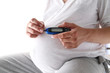 Kobieta w ciąży trzyma glukometr 