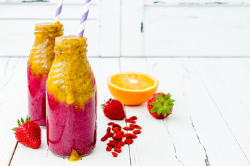 Wall Mural - Healthy breakfast fruit smoothie with superfoods.  Mango goji berry smoothie with chia seeds in vintage bottles over white rustic table. Copy space