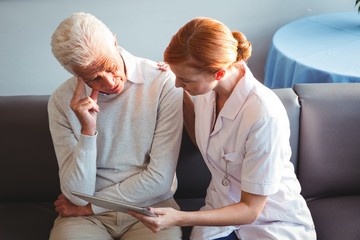 Wall Mural - Nurse and senior man using a digital tablet