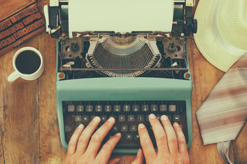 Wall Mural - man typing on vintage typewriter with blank page