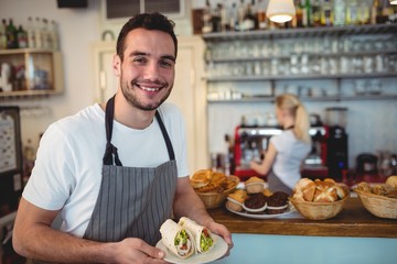 Portrait of happy barista with fresh rolls