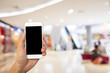 © pushish images - Hand hold blank smartphone on blur supermarket background