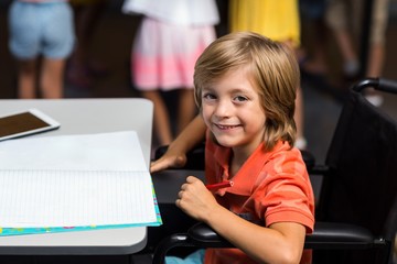 Wall Mural - Smiling boy on wheelchair by table