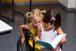 © WavebreakmediaMicro - Girls sitting on wheelchair reading book