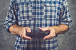 Gamer in plaid shirt playing video game with gamepad