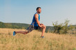 Attractive athletic man in his 30s stretching his legs outdoor preparing for exercise