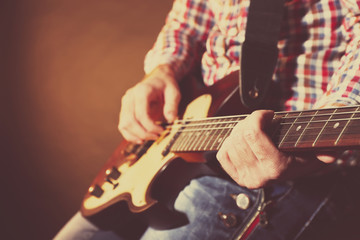 Wall Mural - Young man playing on electric guitar