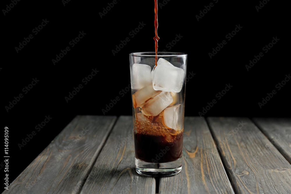 Glass of iced coffee on wooden table