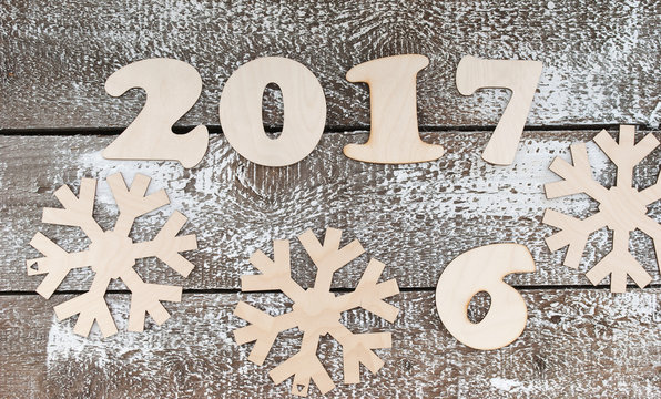 wooden figures of 2017 and snowflakes on a gray table