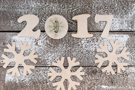 wooden figures of 2017 and snowflakes on a gray table