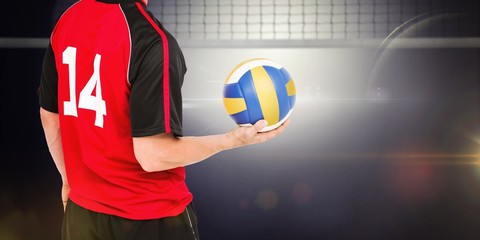 Wall Mural - Composite image of sportsman holding a volleyball