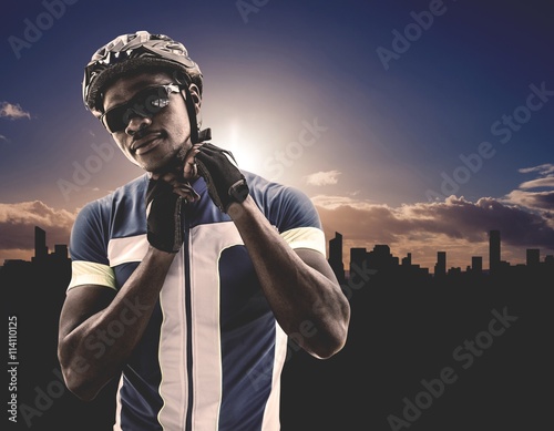 Fotografie, Tablou Composite image of athletic man putting his cycling helmet