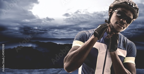 Fotografie, Tablou Composite image of athletic man putting his cycling helmet
