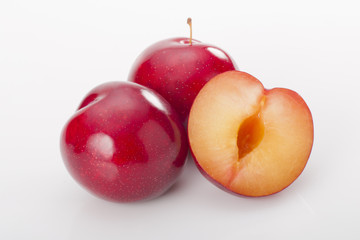 Wall Mural - Red plums on white background