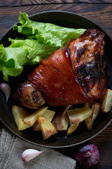 Poster - Close-up of a frying pan with roasted pork knuckle, top view